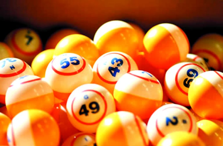 Foto de bolas laranjas e brancas de sorteio de bingo com números