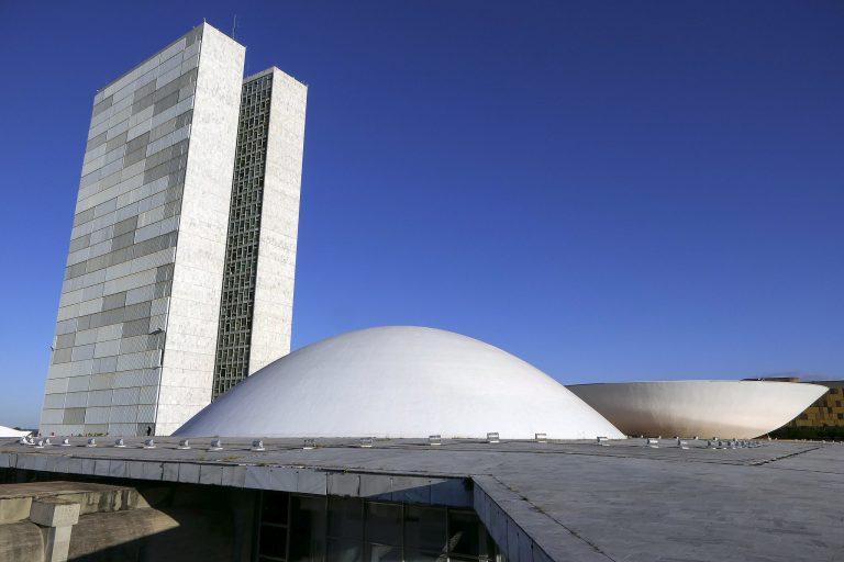 Foto do Congresso Nacional: dois prédios altos e uma cúpula virada para cima e outra cúpula virada para baixo