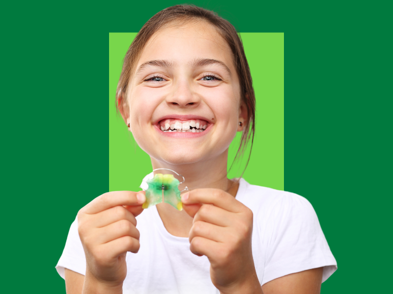 criança, menina, sorrindo enquanto segura um aparelho móvel nas mãos, capa do conteúdo sobre dentes apinhados