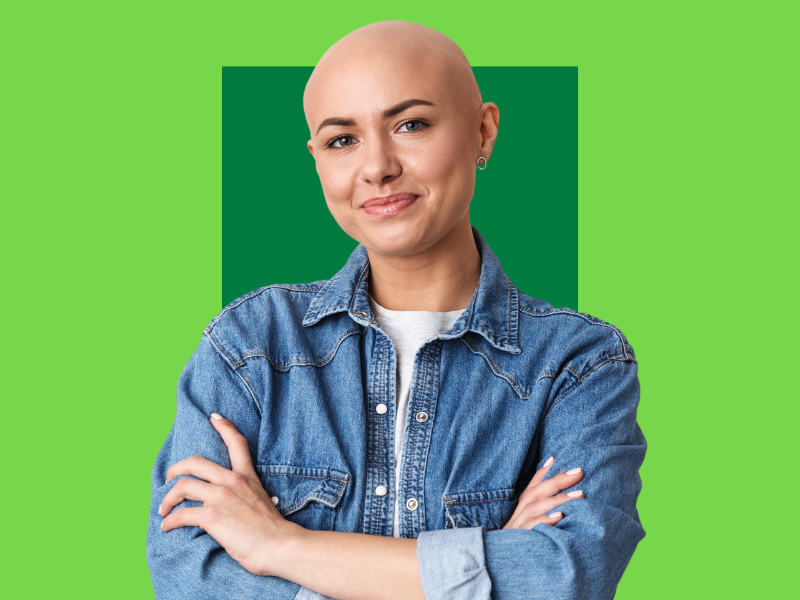 mulher careca, paciente de quimioterapia, sorrindo para a foto com os braços na frente do colo, capa do conteúdo sobre cárie de radiação