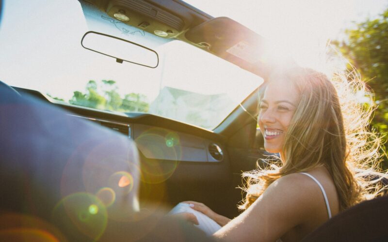 smiling woman sitting inside the vehicle at daytime
