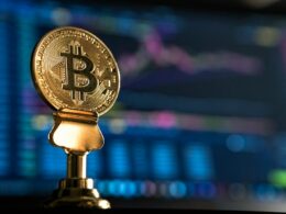 selective focus photo of Bitcoin near monitor