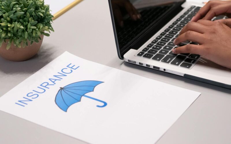 A Paper beside a Person Typing on a Laptop