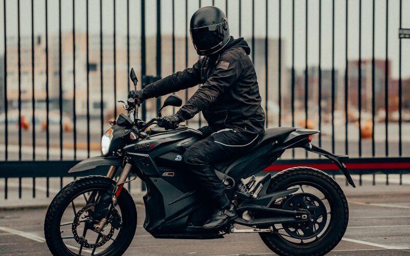 man in black leather jacket riding motorcycle