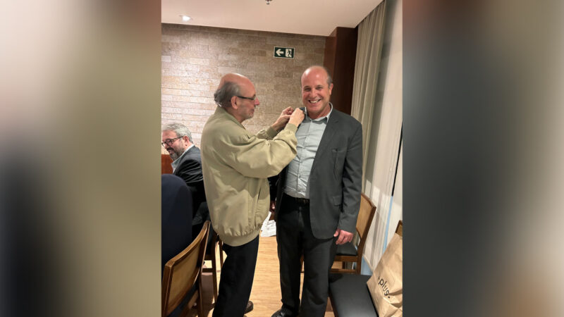 O mais novo confrade, Cássio Cabral Kelly, (D) apresentado e apadrinhado pelo ex-reitor Neival Freitas, recebe o distintivo / Foto: Divulgação