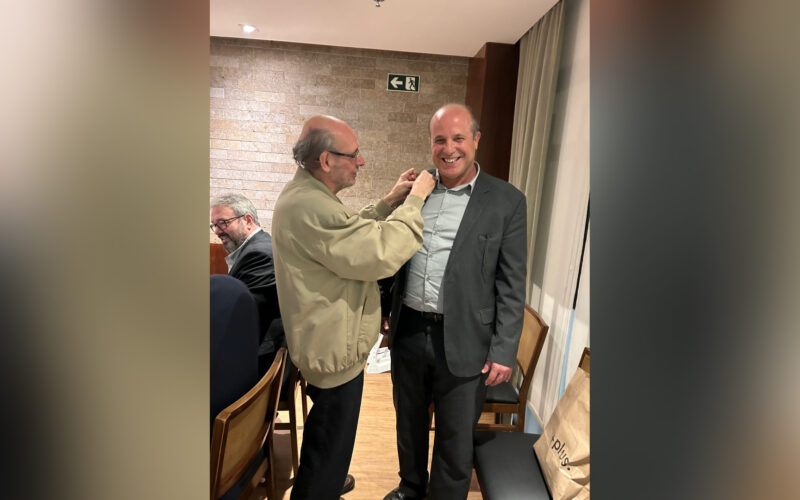 O mais novo confrade, Cássio Cabral Kelly, (D) apresentado e apadrinhado pelo ex-reitor Neival Freitas, recebe o distintivo / Foto: Divulgação