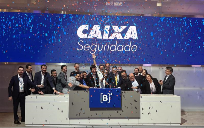 Felipe Mattos (ao centro, de terno preto), Tarso de Tassis (com gravata amarela) e equipe celebram a operação / Foto: CAIXA / Divulgação