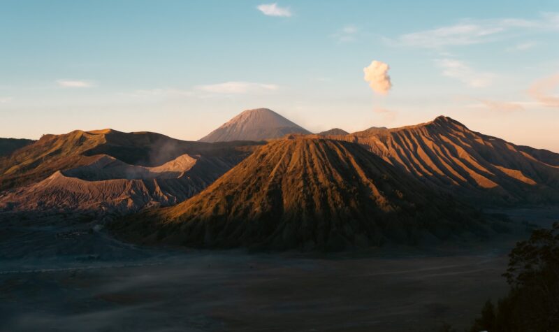 A view of a mountain with a cloud in the sky