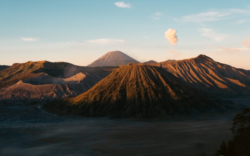 A view of a mountain with a cloud in the sky