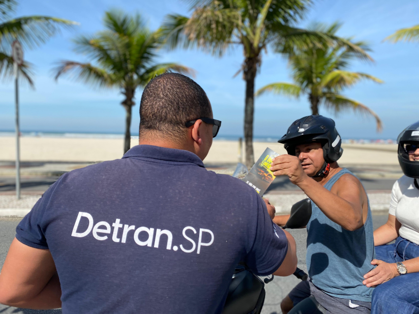 Representante do Detran-SP aborda motociclista em Santos para alertar sobre os perigos da velocidade