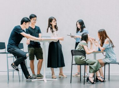 two men and four women meeting in office