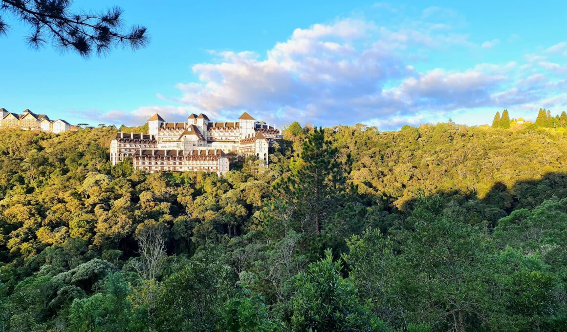 a large building sitting on top of a lush green hillside