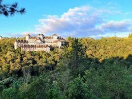 a large building sitting on top of a lush green hillside