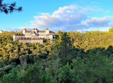 a large building sitting on top of a lush green hillside
