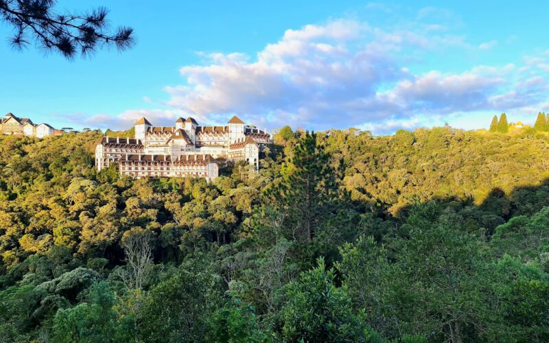 a large building sitting on top of a lush green hillside