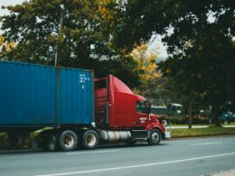 a red semi truck driving down a street