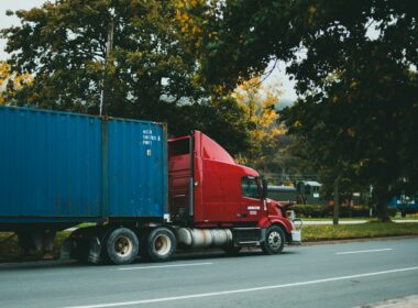 a red semi truck driving down a street