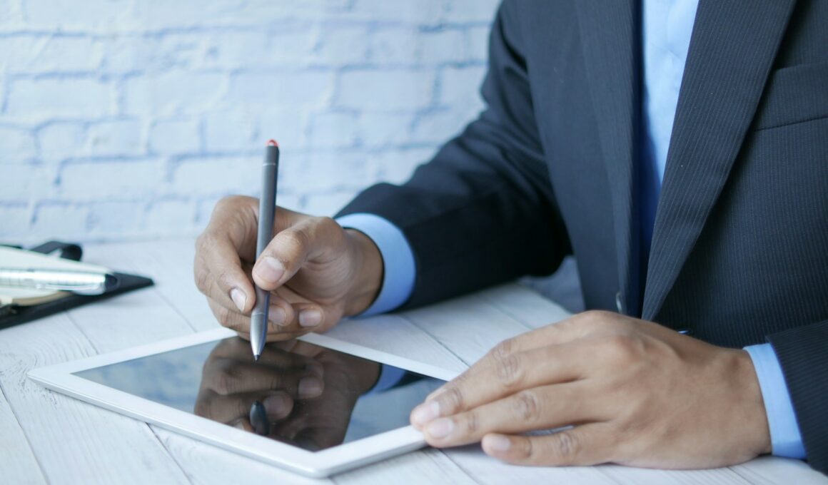 a man in a suit writing on a tablet