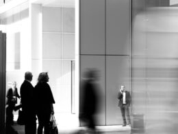 grayscale photo of people walking towards building