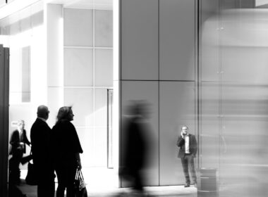 grayscale photo of people walking towards building