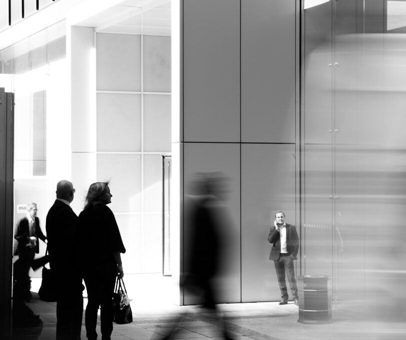 grayscale photo of people walking towards building