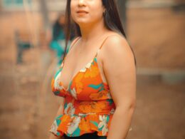 a woman in a floral top poses for a picture
