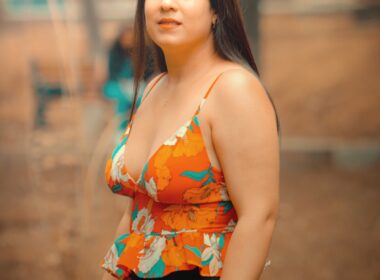 a woman in a floral top poses for a picture