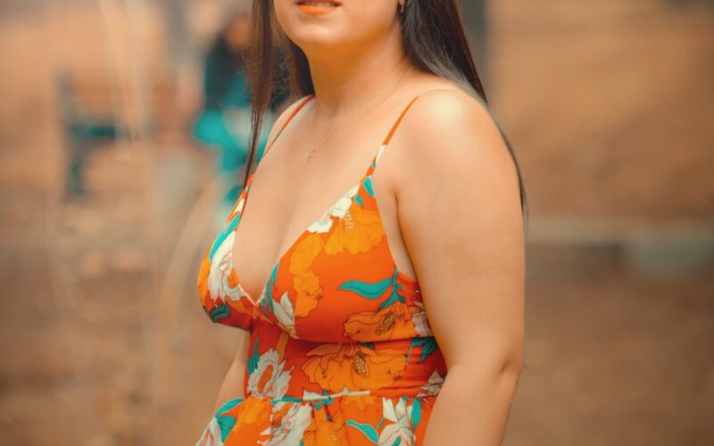 a woman in a floral top poses for a picture