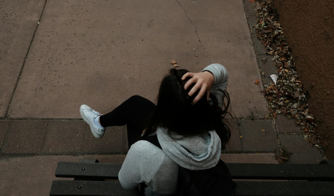 a person sitting on a bench on a sidewalk