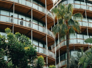 a tall building with balconies and palm trees in front of it