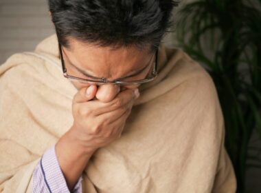 man in brown sweater wearing black framed eyeglasses