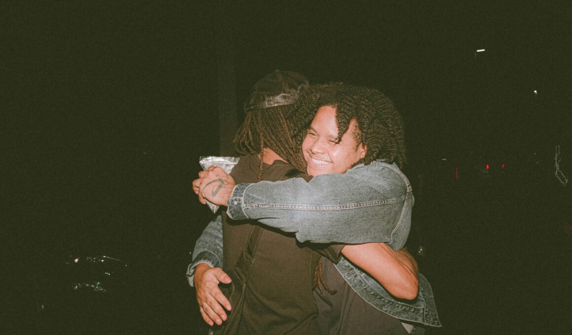 two people hugging each other in the dark