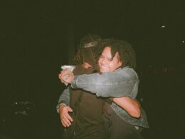 two people hugging each other in the dark