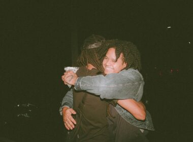 two people hugging each other in the dark
