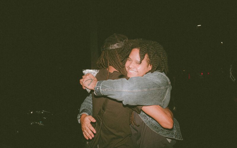 two people hugging each other in the dark