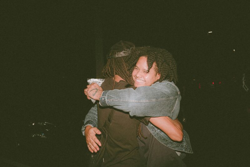 two people hugging each other in the dark