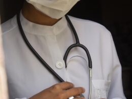 a woman wearing a medical mask and holding a stethoscope