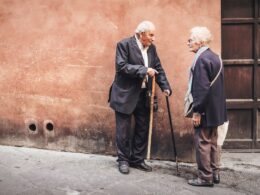 two person talking while standing near wall
