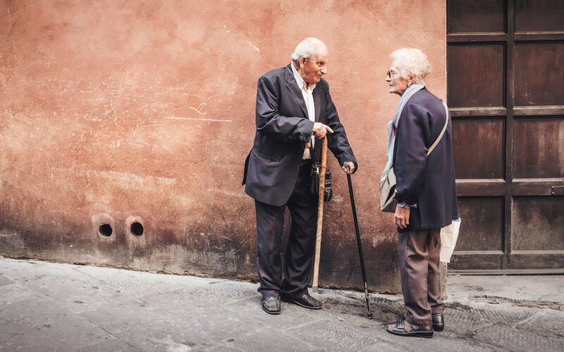 two person talking while standing near wall