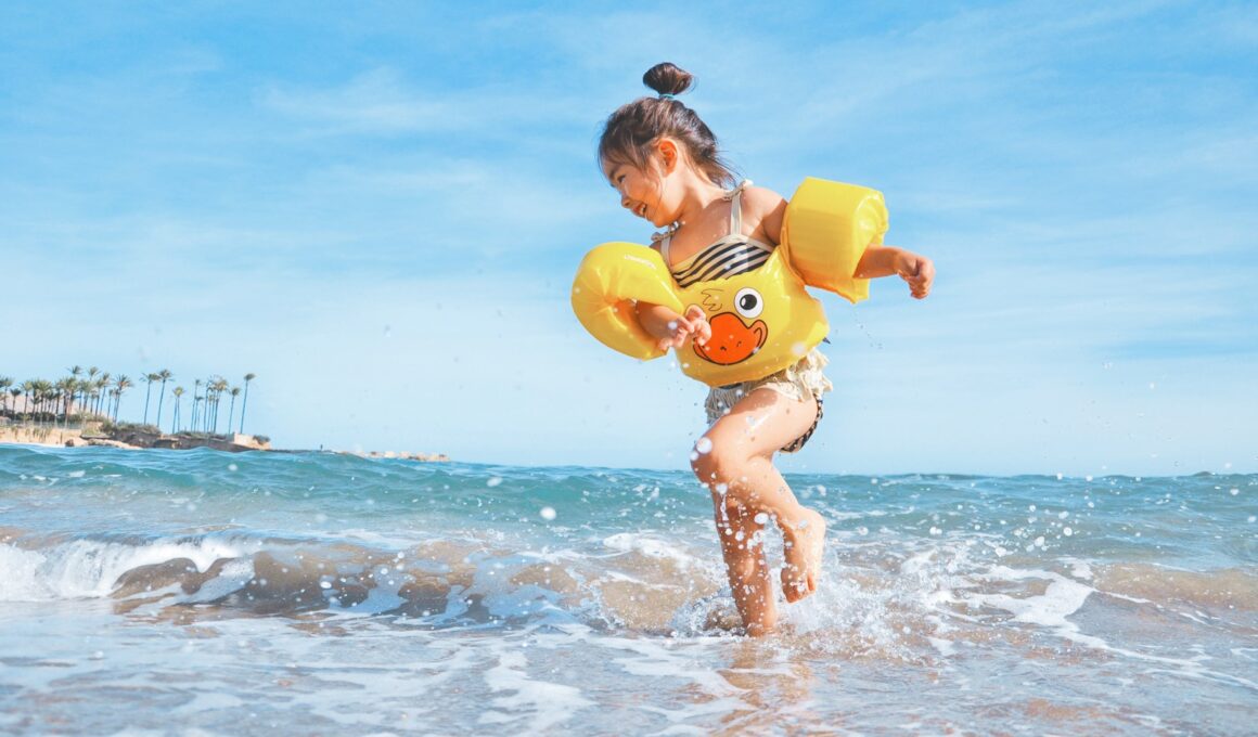 girl playing beside body of water during daytime