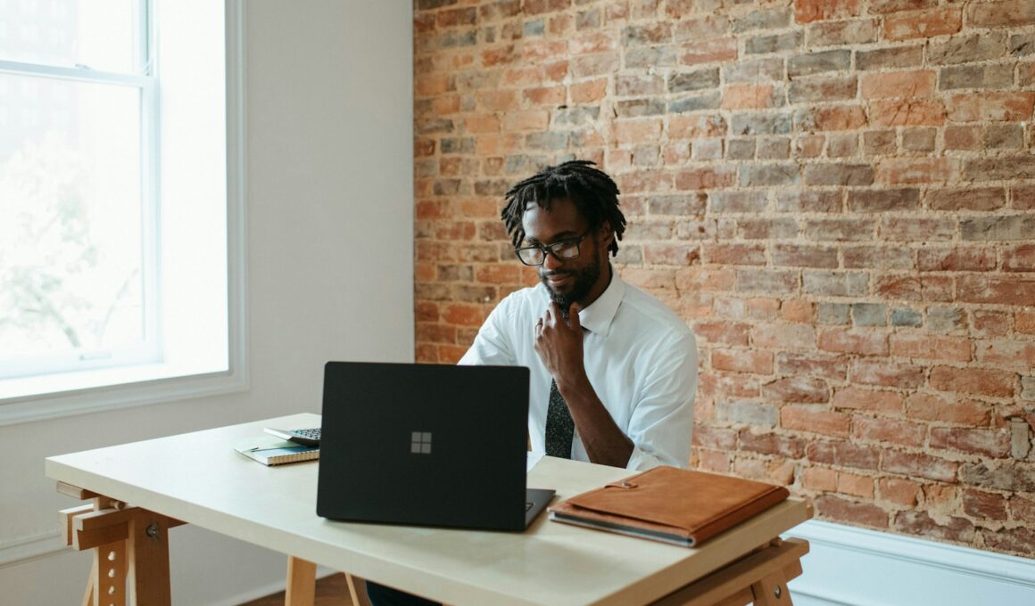 a man sitting at a table in front of a laptop
