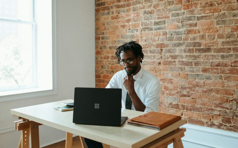 a man sitting at a table in front of a laptop