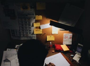 a person sitting at a desk in front of a lamp