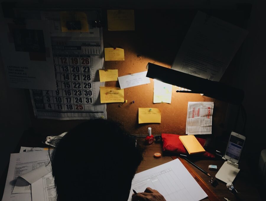 a person sitting at a desk in front of a lamp