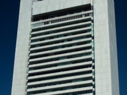 A tall building stands against a blue sky.