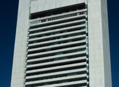 A tall building stands against a blue sky.