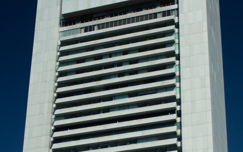 A tall building stands against a blue sky.