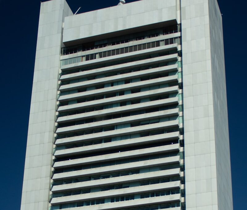 A tall building stands against a blue sky.