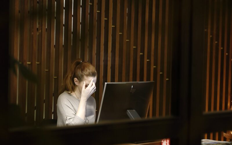 a woman sitting in front of a laptop computer