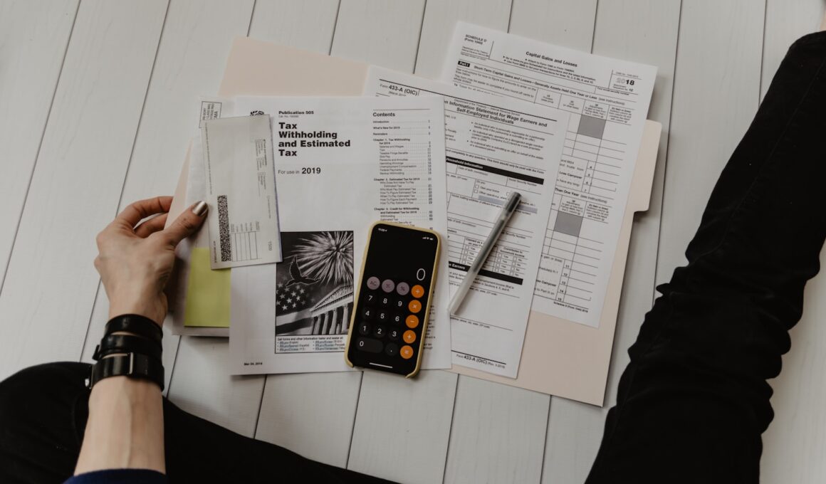 person holding paper near pen and calculator